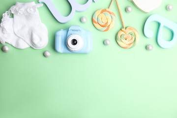 Flat lay composition with toy camera on light green background, space for text. Future photographer
