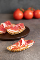 Close up of famous Spanish tapa toasted bread with tomato and Jamon, cured ham.