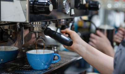 a Barista makes the coffee in the coffee machine