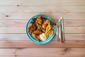 Whole baby grilled chicken with coleslaw and french fries. Western food on table.