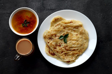 Top view of roti canai, teh tarik and curry