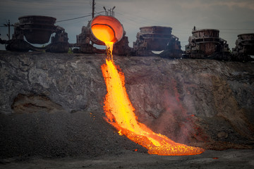 Discharge of metallurgical slag from blast furnaces. Beautiful stream of hot slag - obrazy, fototapety, plakaty
