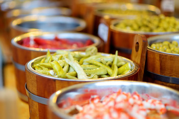 Assorted organic pickled olives, garlic, hot peppers, capers and sundried tomatos sold on a marketplace in Vilnius, Lithuania.