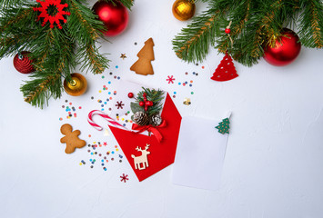 Photo of red envelope, cookies, branches of spruce Christmas decorations.