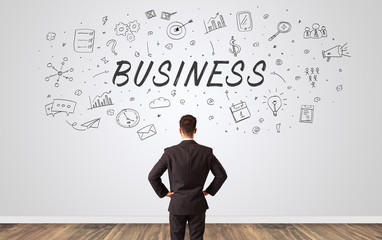 Young manager in doubt looking to a wall with business concept