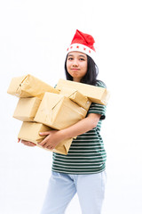 portrait of a young Asian woman wearing a santa hat and wearing casual clothes lifting a pile of gifts