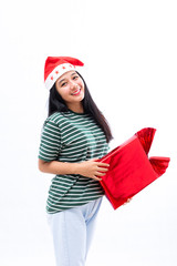 portrait of a young Asian woman wearing a santa hat and wearing casual clothes carrying a red gift