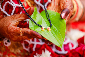 Traditional indian wedding ceremony : Mangalsutra with green leaf holding in hand 