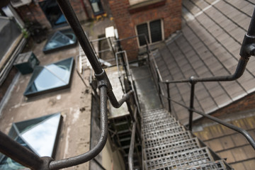 urban new york  style metal vintage steel fire escape ladder stairs in manchester england. Fire escape route on the side of a building saves lives.