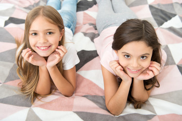 There are many reasons to be happy. Happy kids with cute smiles. Small children relax on bed....