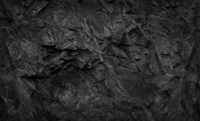 Black rock background. Dark gray stone texture. Black grunge background. Mountain close-up.