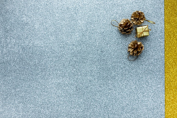 Christmas Gift box and fir cones  are on the gold and silver coloured background. Top view, flat lay, copy space.