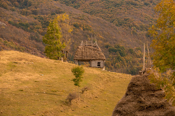 small wooden house with thatched roof in the mountains.