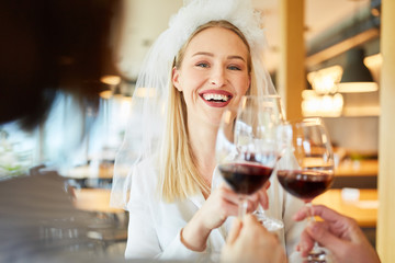 Woman drinking as a laughing bride while drinking wine