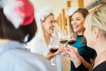 Women drink a glass of red wine with the bride