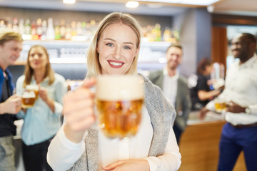 Cheerful woman tasting with a glass of beer