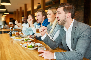 Group of sports fans at the counter in a pub