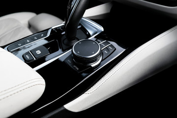 Media and navigation control buttons of a Modern car. Car interior details. White leather interior...