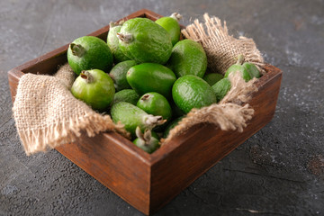 Feijoa fruit in a wooden plate on the table.