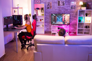 Blond girl playing shooters games in a room with neon light © DC Studio