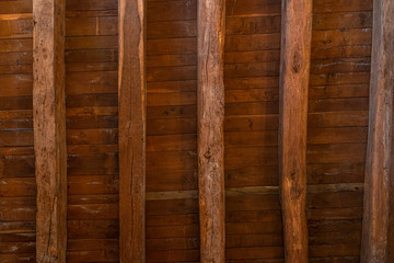 Background made of an old brown ceiling with boards and beams.