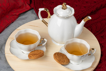 White porcelain cup of tea and oat cookies on a table