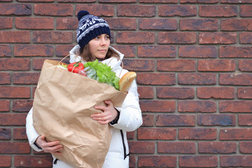 Woman with groceries package near grocery store