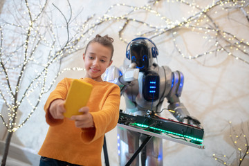 Cute girl making a selfie with robot dj