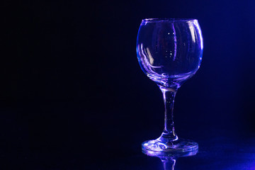 Glossy empty wine glass close up on a dark background