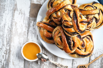 Homemade buns with dark chocolate on a  light rustic  background copy space top view