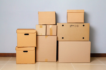 Cardboard boxes for moving on the floor against grey wall