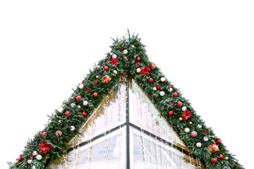 The roof of the building is decorated with spruce branches, Christmas balls, flowers and garlands....