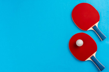 Ping pong racket and ball on blue background - obrazy, fototapety, plakaty