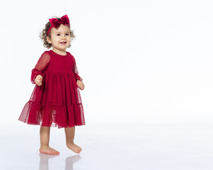 child 2 years old girl in a red dress isolate white background dancing smiling pretty beautiful in a bow festive outfit birthday new year christmas