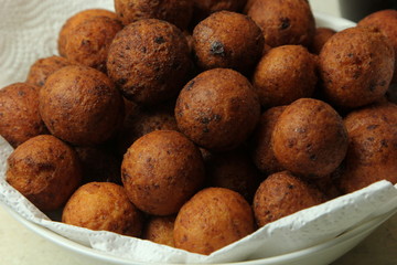 Small balls of freshly baked homemade cottage cheese in the white paper. Freshly made donuts from cottage cheese