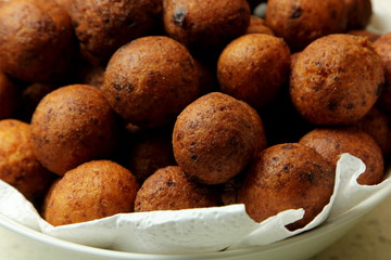 Small balls of freshly baked homemade cottage cheese in the white paper. Freshly made donuts from cottage cheese