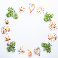 Obraz premium Christmas round frame with fir tree branches, wooden decorations, confetti on grey background, copy space. Round frame with eco decorations and green branches
