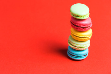 Closeup of a column of colorful macaroon on a red background
