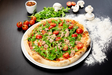 Declicious pizza with ingredients on the side, backed in traditional wooden oven.