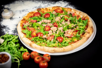 Declicious pizza with ingredients on the side, backed in traditional wooden oven.