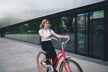 Female cycling on sidewalk in city