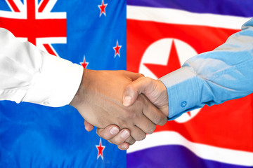 Business handshake on the background of two flags. Men handshake on the background of the New Zealand and North Korea flag. Support concept