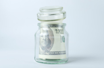 Closeup of closed glass jar full of money savings on the white background