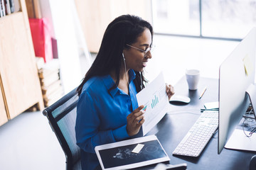 Cheerful black woman demonstrating graphs via video session