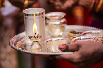 Traditional indian wedding ceremony in Hinduism : Holding puja thali and oil lamp in hand