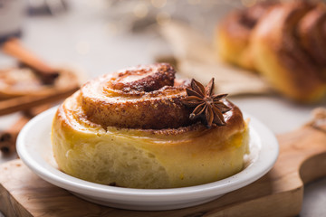 Confectionery baking. Sweet fresh soft roll bun with cinnamon on concrete background.  Christmas  food recipe