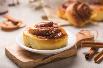 Confectionery baking. Sweet fresh soft roll bun with cinnamon on concrete background.  Christmas  food recipe