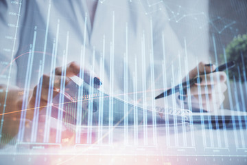 Financial chart drawn over hands taking notes background. Concept of research. Multi exposure