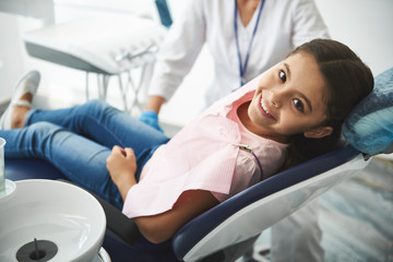 Obraz premium Overjoyed nice girl visiting her professional dentist