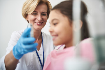 Joyful professional dentist conducting a regular check up